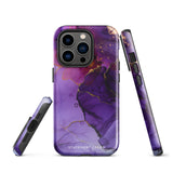 A Statement Cases Golden Orchid Marble for iPhone with a case featuring an abstract design of swirling purple, pink, and gold hues over a white background. The marbled patterns with metallic accents provide dual-layer protection and are impact-resistant. The top of the case has cutouts for the phone's camera lenses and is induction charging compatible.