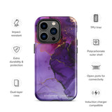 A Statement Cases Golden Orchid Marble for iPhone with a case featuring an abstract design of swirling purple, pink, and gold hues over a white background. The marbled patterns with metallic accents provide dual-layer protection and are impact-resistant. The top of the case has cutouts for the phone's camera lenses and is induction charging compatible.