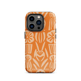 A Savannah Ardiente for iPhone from Statement Cases, featuring a dual-layered phone case in orange with a floral pattern showcasing cream-colored flowers, leaves, and geometric shapes. This impact-resistant polycarbonate case displays "STATEMENT CASES" at the bottom and reveals the camera lenses at the top left corner.