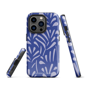 An iPhone encased in the "Mariposa Azul" by Statement Cases, featuring a blue design with an abstract white leaf pattern. The case combines curved and pointed shapes and provides dual-layer protection with TPU lining and impact-resistant polycarbonate. Camera lenses and other top elements remain unobstructed, and "Statement Cases" is inscribed at the bottom.