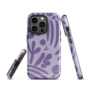 The Luna Morada for iPhone by Statement Cases is a durable phone case with a purple protective exterior featuring abstract dark purple and lavender patterns. The design includes geometric shapes and curves, giving it a modern artistic look. Made from impact-resistant polycarbonate, the lower part of the case prominently displays "STATEMENT CASES.