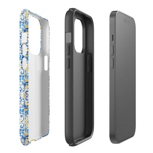 The Blue Mirage for iPhone by Statement Cases features a dual-layered, impact-resistant polycarbonate exterior with a TPU inner liner. Inspired by traditional Portuguese tiles, the blue and yellow patterned case boasts an intricate design of floral and geometric motifs. With its elegant and colorful appearance, the phone's camera is visible at the top left of the case.