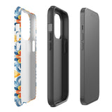 Statement Cases' Mediterranean Bloom for iPhone is showcased, featuring an intricate, colorful pattern. The design includes blue, yellow, and orange floral shapes in a symmetrical arrangement on a light blue background. This durable phone case provides dual-layer protection and is constructed from impact-resistant polycarbonate to safeguard your device.