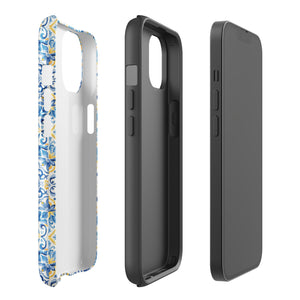 The Blue Mirage for iPhone by Statement Cases features a dual-layered, impact-resistant polycarbonate exterior with a TPU inner liner. Inspired by traditional Portuguese tiles, the blue and yellow patterned case boasts an intricate design of floral and geometric motifs. With its elegant and colorful appearance, the phone's camera is visible at the top left of the case.