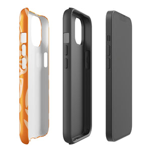 A Savannah Ardiente for iPhone from Statement Cases, featuring a dual-layered phone case in orange with a floral pattern showcasing cream-colored flowers, leaves, and geometric shapes. This impact-resistant polycarbonate case displays "STATEMENT CASES" at the bottom and reveals the camera lenses at the top left corner.