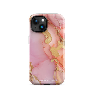 The Gold Blush Marble for iPhone showcases a glossy, marble-patterned case in shades of pink and gold. The decorative design features swirling patterns, seamlessly blending the colors. Crafted with impact-resistant polycarbonate for superior phone protection, "Statement Cases" is written in white at the bottom.