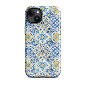 The Blue Mirage for iPhone by Statement Cases features a dual-layered, impact-resistant polycarbonate exterior with a TPU inner liner. Inspired by traditional Portuguese tiles, the blue and yellow patterned case boasts an intricate design of floral and geometric motifs. With its elegant and colorful appearance, the phone's camera is visible at the top left of the case.