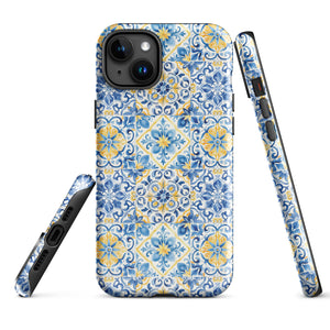 The Blue Mirage for iPhone by Statement Cases features a dual-layered, impact-resistant polycarbonate exterior with a TPU inner liner. Inspired by traditional Portuguese tiles, the blue and yellow patterned case boasts an intricate design of floral and geometric motifs. With its elegant and colorful appearance, the phone's camera is visible at the top left of the case.