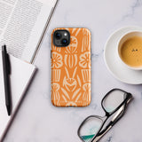 A Savannah Ardiente for iPhone from Statement Cases, featuring a dual-layered phone case in orange with a floral pattern showcasing cream-colored flowers, leaves, and geometric shapes. This impact-resistant polycarbonate case displays "STATEMENT CASES" at the bottom and reveals the camera lenses at the top left corner.