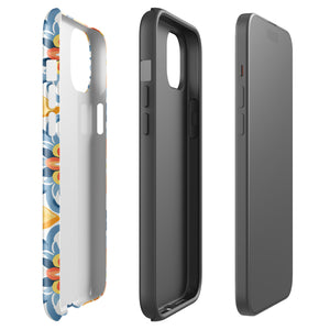 Statement Cases' Mediterranean Bloom for iPhone is showcased, featuring an intricate, colorful pattern. The design includes blue, yellow, and orange floral shapes in a symmetrical arrangement on a light blue background. This durable phone case provides dual-layer protection and is constructed from impact-resistant polycarbonate to safeguard your device.