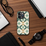 A Smartphone with a durable Old World Mosaic for iPhone case by Statement Cases showcasing a geometric pattern in shades of green, beige, and white. The symmetrical, angular designs create an almost star-like appearance. The impact-resistant polycarbonate construction ensures protection while the camera lenses remain visible at the top left corner.