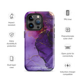 A Statement Cases Golden Orchid Marble for iPhone with a case featuring an abstract design of swirling purple, pink, and gold hues over a white background. The marbled patterns with metallic accents provide dual-layer protection and are impact-resistant. The top of the case has cutouts for the phone's camera lenses and is induction charging compatible.