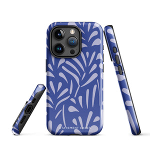 An iPhone encased in the "Mariposa Azul" by Statement Cases, featuring a blue design with an abstract white leaf pattern. The case combines curved and pointed shapes and provides dual-layer protection with TPU lining and impact-resistant polycarbonate. Camera lenses and other top elements remain unobstructed, and "Statement Cases" is inscribed at the bottom.