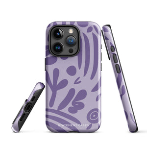 The Luna Morada for iPhone by Statement Cases is a durable phone case with a purple protective exterior featuring abstract dark purple and lavender patterns. The design includes geometric shapes and curves, giving it a modern artistic look. Made from impact-resistant polycarbonate, the lower part of the case prominently displays "STATEMENT CASES.