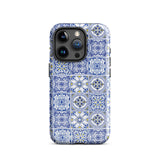 The Lisboa Azul for iPhone by Statement Cases is a smartphone adorned with a dual-layer protection phone case, featuring an intricate blue and white tile pattern. The design showcases various geometric and floral motifs, forming a visually appealing mosaic effect. The impact-resistant camera lenses and flash are prominently visible at the top left.