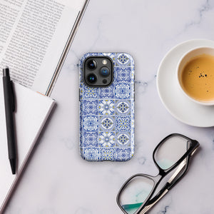 The Lisboa Azul for iPhone by Statement Cases is a smartphone adorned with a dual-layer protection phone case, featuring an intricate blue and white tile pattern. The design showcases various geometric and floral motifs, forming a visually appealing mosaic effect. The impact-resistant camera lenses and flash are prominently visible at the top left.