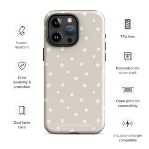 A beige Classic Nude for iPhone case with white polka dots, designed for the iPhone 15 Pro Max, covering the back of a phone with three visible camera lenses and one flash positioned at the upper left corner. This protective iPhone case features "Statement Cases" in small capital letters at the bottom.