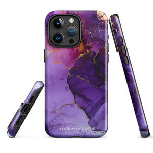 A Statement Cases Golden Orchid Marble for iPhone with a case featuring an abstract design of swirling purple, pink, and gold hues over a white background. The marbled patterns with metallic accents provide dual-layer protection and are impact-resistant. The top of the case has cutouts for the phone's camera lenses and is induction charging compatible.
