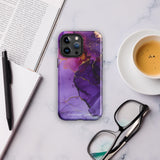 A Statement Cases Golden Orchid Marble for iPhone with a case featuring an abstract design of swirling purple, pink, and gold hues over a white background. The marbled patterns with metallic accents provide dual-layer protection and are impact-resistant. The top of the case has cutouts for the phone's camera lenses and is induction charging compatible.