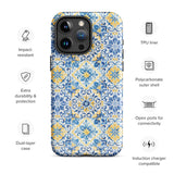 The Blue Mirage for iPhone by Statement Cases features a dual-layered, impact-resistant polycarbonate exterior with a TPU inner liner. Inspired by traditional Portuguese tiles, the blue and yellow patterned case boasts an intricate design of floral and geometric motifs. With its elegant and colorful appearance, the phone's camera is visible at the top left of the case.