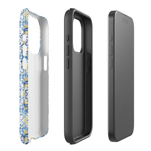 The Blue Mirage for iPhone by Statement Cases features a dual-layered, impact-resistant polycarbonate exterior with a TPU inner liner. Inspired by traditional Portuguese tiles, the blue and yellow patterned case boasts an intricate design of floral and geometric motifs. With its elegant and colorful appearance, the phone's camera is visible at the top left of the case.