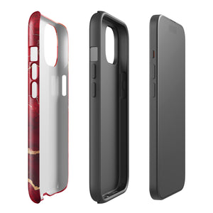 A smartphone in a protective Scarlet Marble for iPhone case by Statement Cases with a red and gold marbled abstract design. The case has "Statement Cases" written at the bottom. The iPhone 15 Pro Max features three camera lenses and a flash on the top left corner.