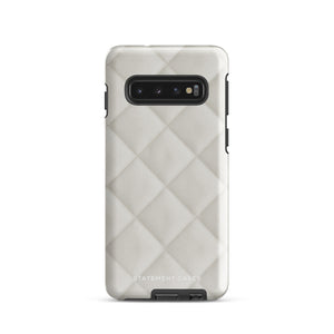 A Quilted Delight for Samsung with a quilted pattern in a light cream color made from impact-resistant materials. The case has a cutout for the camera module with four lenses and a flash. "Statement Cases" is branded at the bottom in white text.