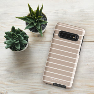 A smartphone with a beige striped case lies on a light wooden surface next to two small potted succulents. The impact-resistant Au Naturale for Samsung case has "Statement Cases" printed at the bottom.