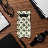 The Grand Estate Mosaic for Samsung features a geometric design with interlocking circles and X-shaped patterns in green, beige, and white tones. The impact-resistant, dual-layer design creates a modern, symmetrical appearance. "Statement Cases" is printed at the bottom of the case.
