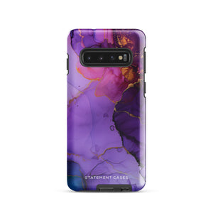 The Golden Orchid Marble for Samsung by Statement Cases is a smartphone adorned with a vibrant, abstract phone case showcasing a mix of purple, pink, and gold colors. Crafted from impact-resistant materials, it features a camera module with four lenses and a flash. At the bottom of the shock-absorbing phone case, you’ll find the text "STATEMENT CASES" in white.