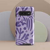 Introducing the Luna Morada for Samsung, a striking smartphone case from Statement Cases. This decorative purple cover boasts abstract floral and organic patterns in darker hues and is designed to absorb shocks. The impact-resistant case features a camera cutout that accommodates five lenses, with the brand name "STATEMENT CASES" elegantly printed at the bottom center.