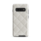 A Quilted Delight for Samsung with a quilted pattern in a light cream color made from impact-resistant materials. The case has a cutout for the camera module with four lenses and a flash. "Statement Cases" is branded at the bottom in white text.