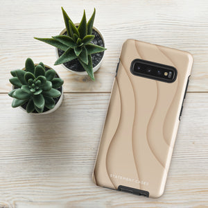 A Sandy Serenity for Samsung encased in a beige, impact-resistant phone case with wavy, textured patterns. Four camera lenses are visible on the back. The lower part of the dual-layer design case displays the text "Statement Cases.