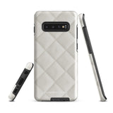 A Quilted Delight for Samsung with a quilted pattern in a light cream color made from impact-resistant materials. The case has a cutout for the camera module with four lenses and a flash. "Statement Cases" is branded at the bottom in white text.
