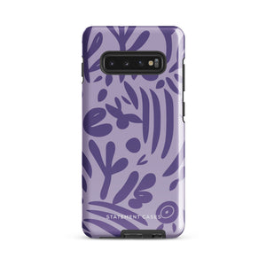 Introducing the Luna Morada for Samsung, a striking smartphone case from Statement Cases. This decorative purple cover boasts abstract floral and organic patterns in darker hues and is designed to absorb shocks. The impact-resistant case features a camera cutout that accommodates five lenses, with the brand name "STATEMENT CASES" elegantly printed at the bottom center.