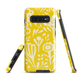 The Sol Dorado for Samsung by Statement Cases is a durable phone case featuring a bright yellow background adorned with an abstract white floral pattern, showcasing various flowers and leaves. Near the bottom edge, the text "STATEMENT CASE" highlights its dual-layer design for enhanced durability.