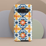 The Mediterranean Bloom for Samsung by Statement Cases features intricate, colorful floral patterns in blue, orange, and yellow. The design covers the entire back of the case, surrounding the camera cutout. Shock-absorbing and impact-resistant, it ensures protection while the brand "Statement Cases" is subtly printed near the bottom.