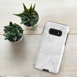 A dual-layer design smartphone case with a white marble pattern features three large camera lenses and a smaller one on the back. "Statement Cases" is subtly printed near the bottom. The minimalistic, matte finish offers impact-resistant protection with style.