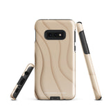 A Sandy Serenity for Samsung encased in a beige, impact-resistant phone case with wavy, textured patterns. Four camera lenses are visible on the back. The lower part of the dual-layer design case displays the text "Statement Cases.