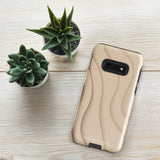 A Sandy Serenity for Samsung encased in a beige, impact-resistant phone case with wavy, textured patterns. Four camera lenses are visible on the back. The lower part of the dual-layer design case displays the text "Statement Cases.