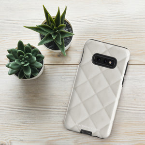 A Quilted Delight for Samsung with a quilted pattern in a light cream color made from impact-resistant materials. The case has a cutout for the camera module with four lenses and a flash. "Statement Cases" is branded at the bottom in white text.