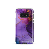 The Golden Orchid Marble for Samsung by Statement Cases is a smartphone adorned with a vibrant, abstract phone case showcasing a mix of purple, pink, and gold colors. Crafted from impact-resistant materials, it features a camera module with four lenses and a flash. At the bottom of the shock-absorbing phone case, you’ll find the text "STATEMENT CASES" in white.