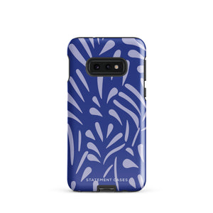 The Mariposa Azul for Samsung smartphone case from Statement Cases is adorned with an impact-resistant design featuring light purple abstract shapes on a blue background. This dual-layer case proudly displays the text "STATEMENT CASES" at the bottom, ensuring that the camera lenses and buttons of your phone remain clearly visible.