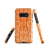 This stylish smartphone accessory, the Savannah Ardiente for Samsung by Statement Cases, features a shock-absorbing, colorful patterned case adorned with abstract flower designs in beige on an orange background. This impact-resistant phone case wraps around the back of your device, providing robust protection for its multiple camera lenses in the corner.