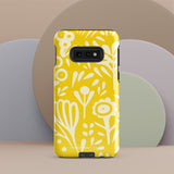 The Sol Dorado for Samsung by Statement Cases is a durable phone case featuring a bright yellow background adorned with an abstract white floral pattern, showcasing various flowers and leaves. Near the bottom edge, the text "STATEMENT CASE" highlights its dual-layer design for enhanced durability.