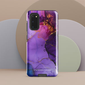 The Golden Orchid Marble for Samsung by Statement Cases is a smartphone adorned with a vibrant, abstract phone case showcasing a mix of purple, pink, and gold colors. Crafted from impact-resistant materials, it features a camera module with four lenses and a flash. At the bottom of the shock-absorbing phone case, you’ll find the text "STATEMENT CASES" in white.