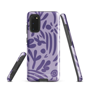 Introducing the Luna Morada for Samsung, a striking smartphone case from Statement Cases. This decorative purple cover boasts abstract floral and organic patterns in darker hues and is designed to absorb shocks. The impact-resistant case features a camera cutout that accommodates five lenses, with the brand name "STATEMENT CASES" elegantly printed at the bottom center.