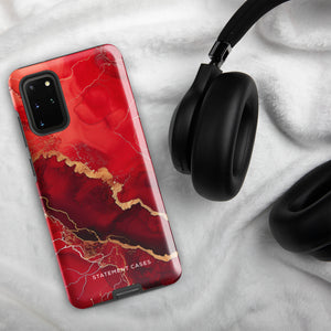 A red and black Scarlet Marble for Samsung with a marble-like pattern and gold accents, designed for a phone with multiple rear cameras. This tough phone case features an impact-resistant, dual-layer design and showcases the brand name "Statement Cases" near the bottom.