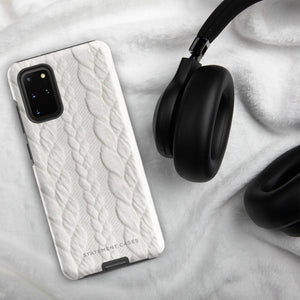 A stylish, impact-resistant phone case with a textured white braided design, covering the back of a smartphone. The dual-layer design features cutouts for the camera and buttons, and "Cozy Knit Bliss for Samsung" by Statement Cases is embossed at the bottom.