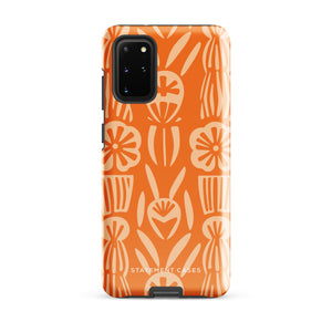 This stylish smartphone accessory, the Savannah Ardiente for Samsung by Statement Cases, features a shock-absorbing, colorful patterned case adorned with abstract flower designs in beige on an orange background. This impact-resistant phone case wraps around the back of your device, providing robust protection for its multiple camera lenses in the corner.